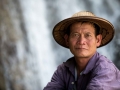 Farmer keeping his buffaloes sitting in front of a waterfall